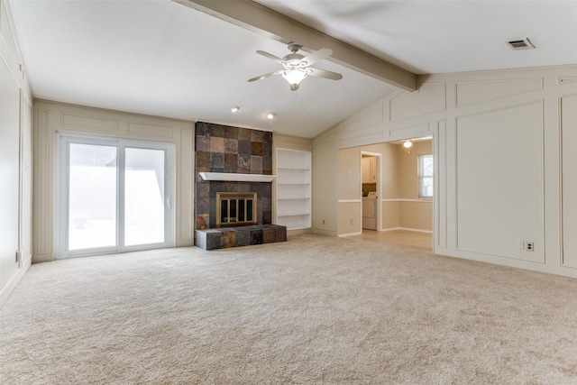 unfurnished living room featuring visible vents, a ceiling fan, a decorative wall, and carpet