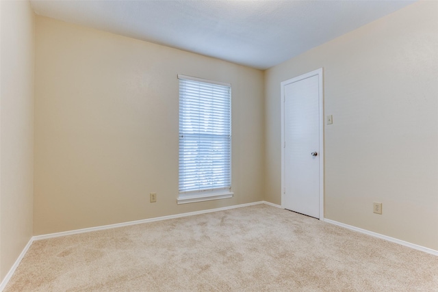 carpeted spare room featuring baseboards