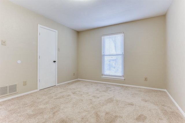 spare room with visible vents, baseboards, and carpet