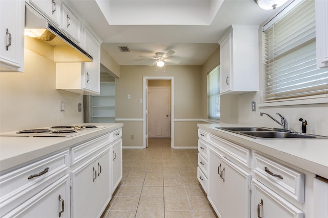 kitchen featuring visible vents, a sink, under cabinet range hood, white electric cooktop, and light tile patterned flooring