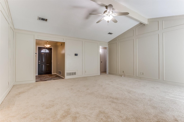 carpeted spare room featuring a decorative wall, a ceiling fan, and visible vents