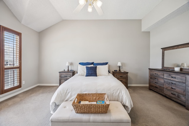 carpeted bedroom with ceiling fan, a textured ceiling, baseboards, and vaulted ceiling