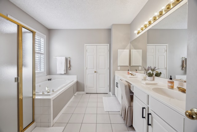 full bath with tile patterned floors, a sink, a textured ceiling, double vanity, and a bath