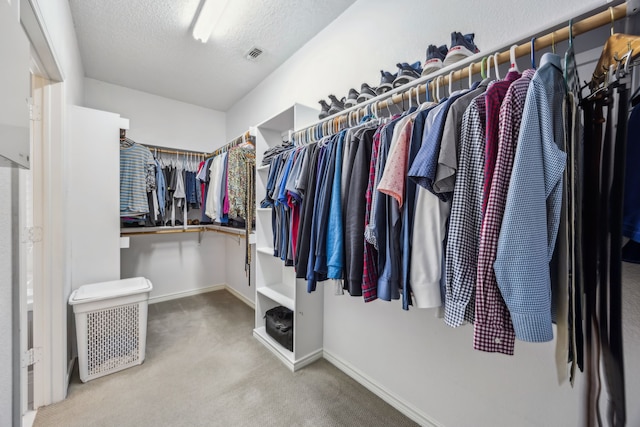 walk in closet featuring visible vents and carpet flooring