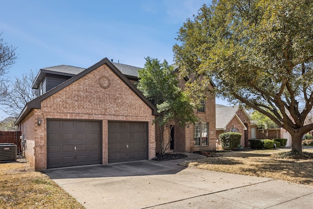 traditional-style house featuring fence, central AC unit, driveway, an attached garage, and brick siding