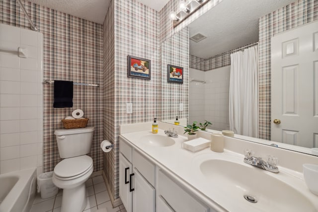 bathroom featuring a sink, a textured ceiling, and wallpapered walls