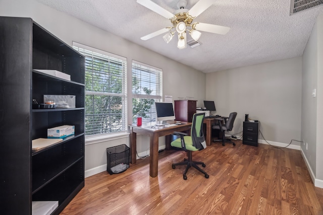 office area featuring visible vents, a textured ceiling, and wood finished floors