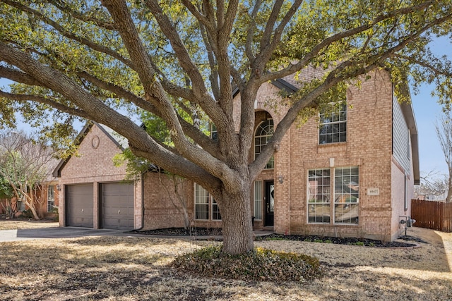 view of front of property with concrete driveway, an attached garage, fence, and brick siding