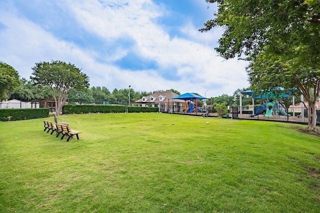 surrounding community with a yard, fence, and playground community