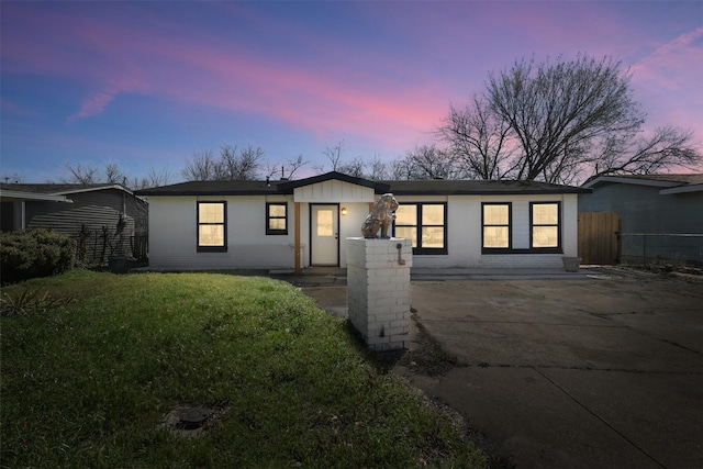 mid-century inspired home with fence and a lawn