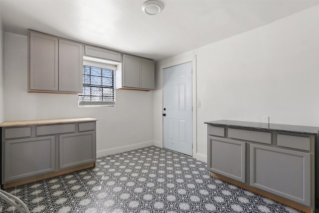 kitchen with tile patterned floors, gray cabinets, and baseboards