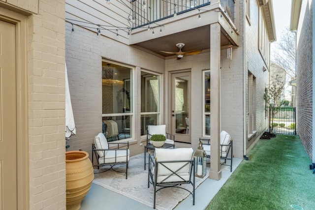 view of patio featuring a balcony, a ceiling fan, and fence