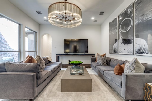 living area with a notable chandelier, recessed lighting, visible vents, and arched walkways