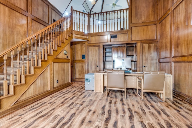 unfurnished office featuring light wood-type flooring and wood walls