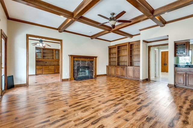 unfurnished living room featuring coffered ceiling, wood finished floors, ceiling fan, and a premium fireplace