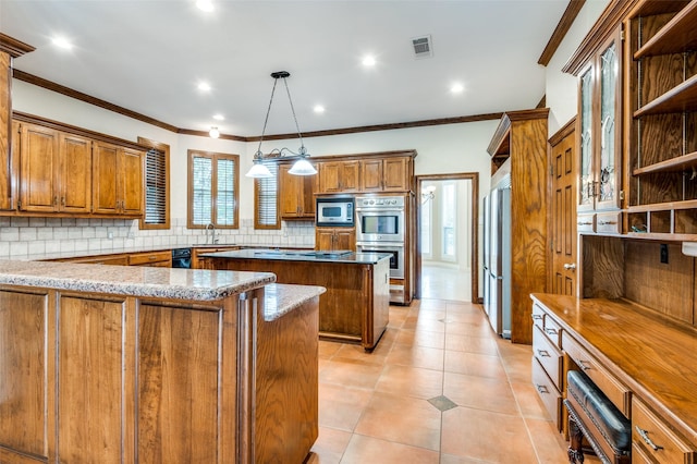 kitchen with tasteful backsplash, a center island, brown cabinets, stainless steel appliances, and a sink