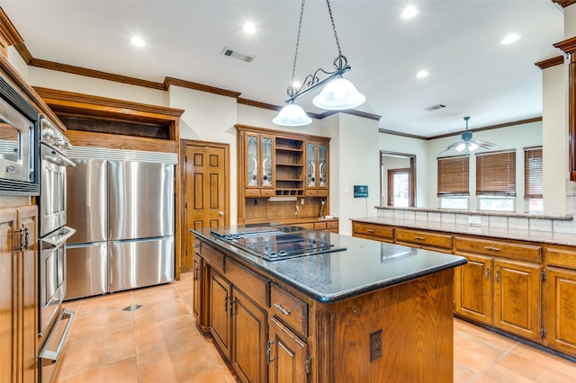 kitchen featuring visible vents, brown cabinets, a center island, and stainless steel appliances