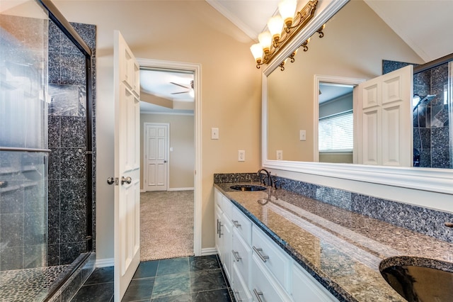 full bath with a sink, a stall shower, double vanity, and vaulted ceiling