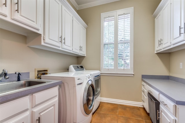 washroom featuring cabinet space, plenty of natural light, washing machine and dryer, and crown molding