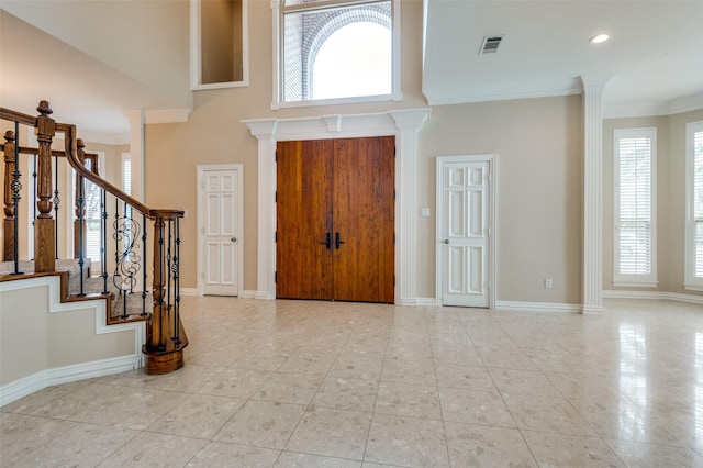 foyer entrance with stairway, visible vents, a wealth of natural light, and ornamental molding