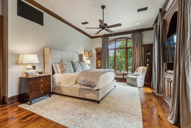 bedroom with crown molding, wood finished floors, and visible vents