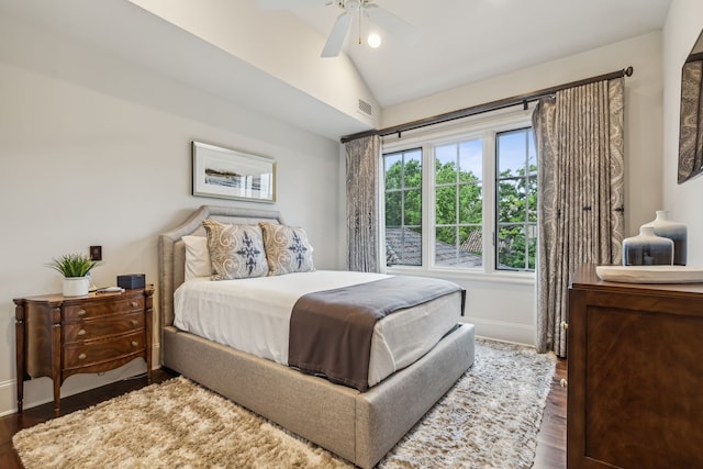 bedroom featuring a ceiling fan, baseboards, visible vents, dark wood-style flooring, and vaulted ceiling