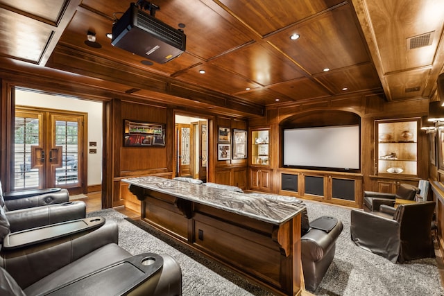 carpeted home theater featuring wooden walls, coffered ceiling, wood ceiling, and built in shelves