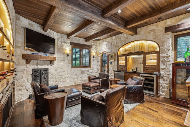 interior space featuring wine cooler, wood-type flooring, a fireplace, indoor wet bar, and wood ceiling