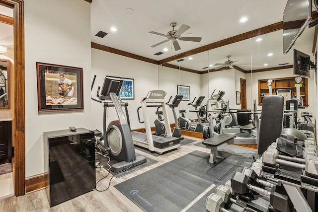 gym with wood finished floors, baseboards, a ceiling fan, visible vents, and ornamental molding