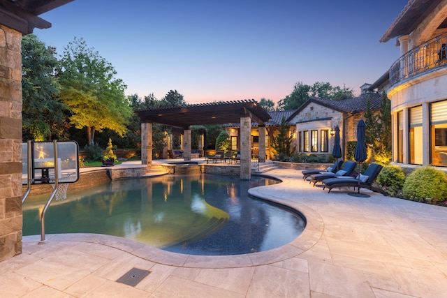 pool at dusk featuring an outdoor pool, a patio area, and a pergola