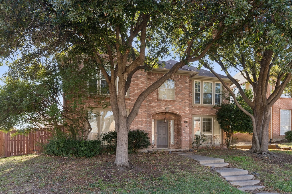 view of front of property with brick siding and fence