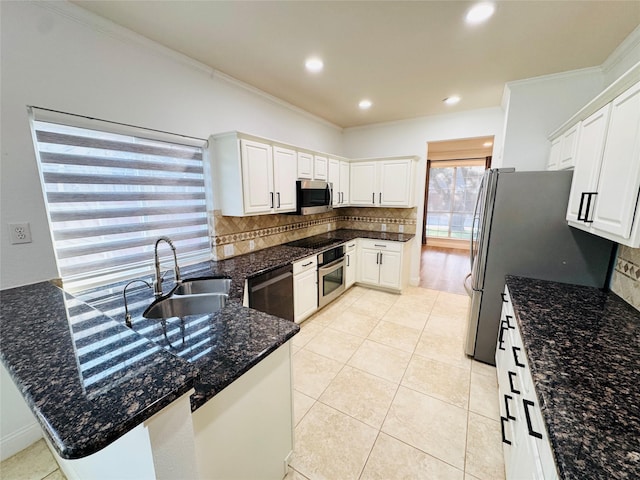 kitchen featuring light tile patterned floors, ornamental molding, decorative backsplash, black appliances, and a sink