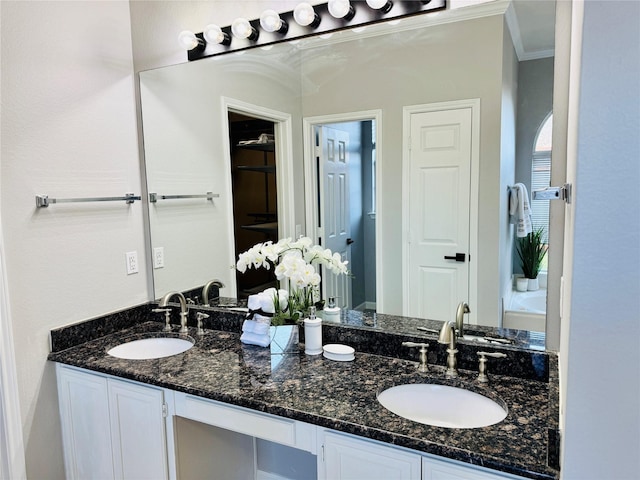 bathroom with double vanity, ornamental molding, and a sink