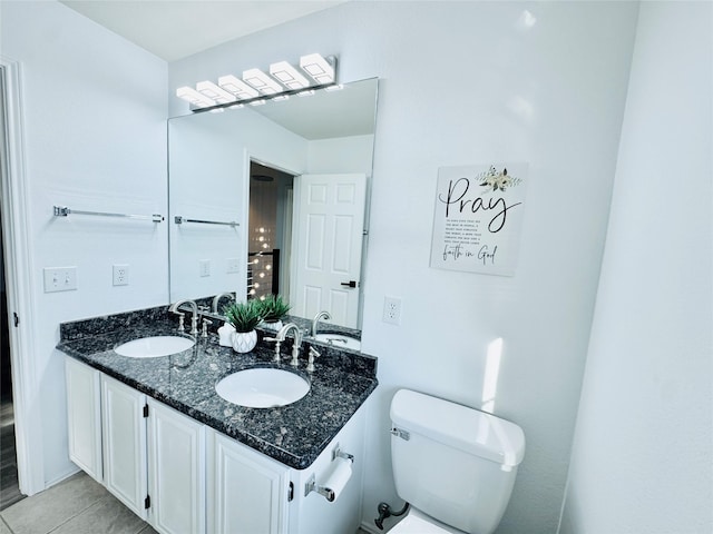 bathroom with a sink, toilet, and double vanity