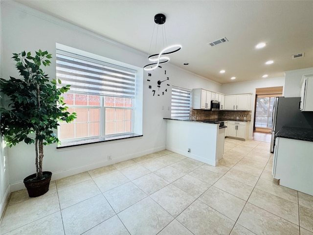 kitchen featuring visible vents, decorative light fixtures, white cabinetry, a peninsula, and decorative backsplash