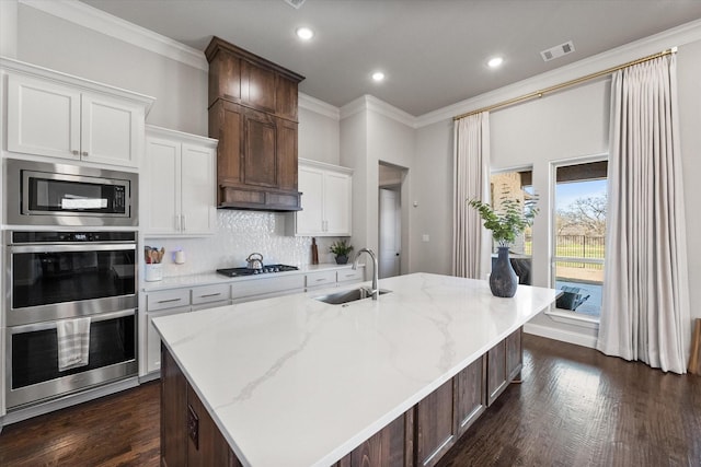 kitchen with a sink, visible vents, tasteful backsplash, and crown molding