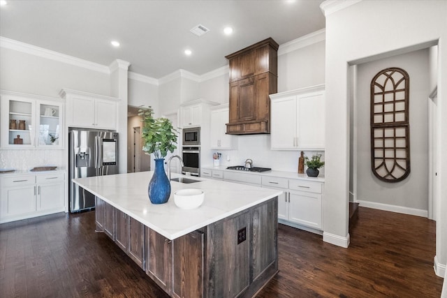 kitchen featuring dark wood finished floors, a large island with sink, appliances with stainless steel finishes, and a sink