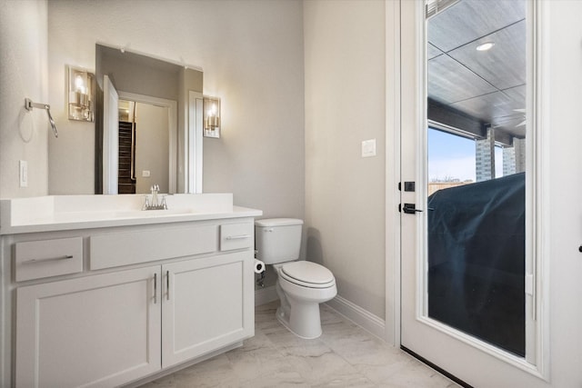 half bath with vanity, toilet, baseboards, and marble finish floor