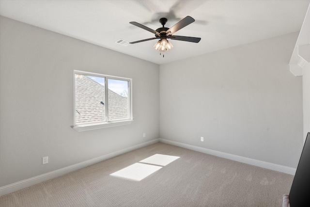 empty room with light colored carpet, baseboards, and ceiling fan