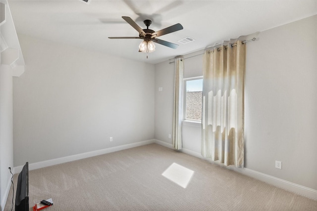 carpeted empty room featuring baseboards, visible vents, and ceiling fan