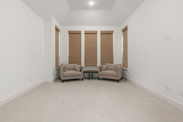 living area with baseboards and light colored carpet