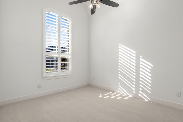 carpeted spare room featuring baseboards and a ceiling fan