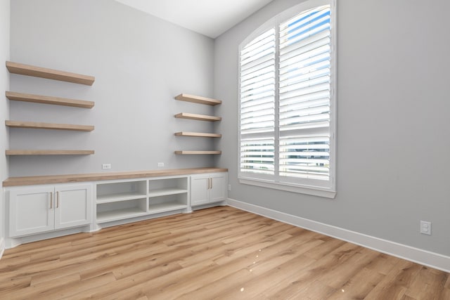 unfurnished office featuring light wood-style flooring and baseboards