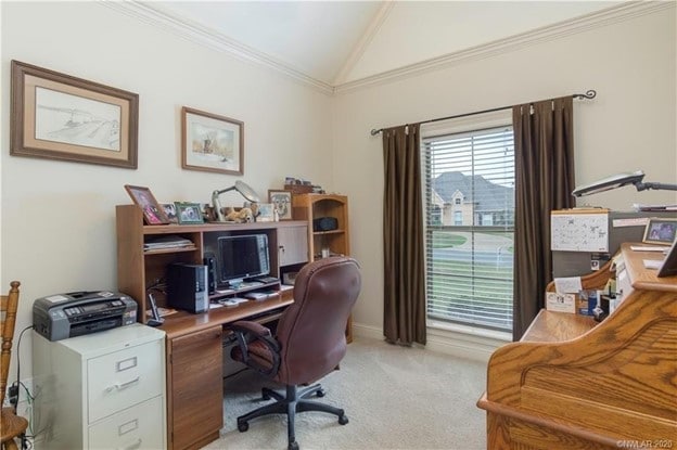 office area featuring light carpet, lofted ceiling, and ornamental molding