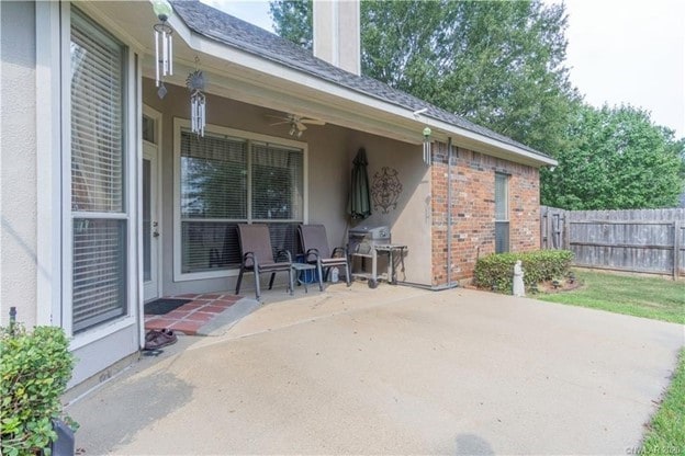 view of patio / terrace with area for grilling, a ceiling fan, and fence