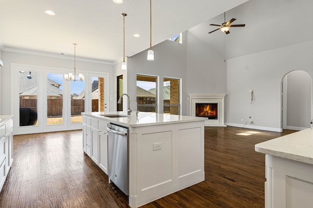 kitchen featuring dark wood finished floors, a warm lit fireplace, a sink, ceiling fan with notable chandelier, and open floor plan