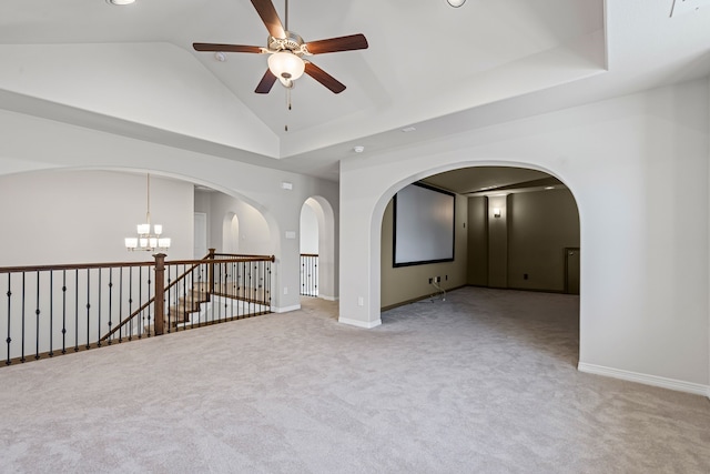 spare room featuring baseboards, arched walkways, light colored carpet, and ceiling fan with notable chandelier