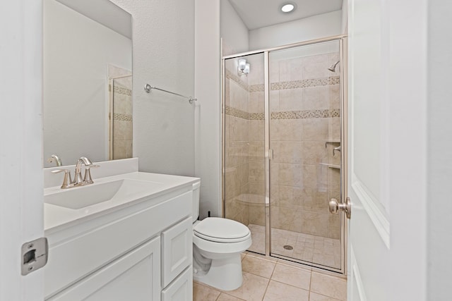 bathroom featuring vanity, a shower stall, toilet, and tile patterned floors