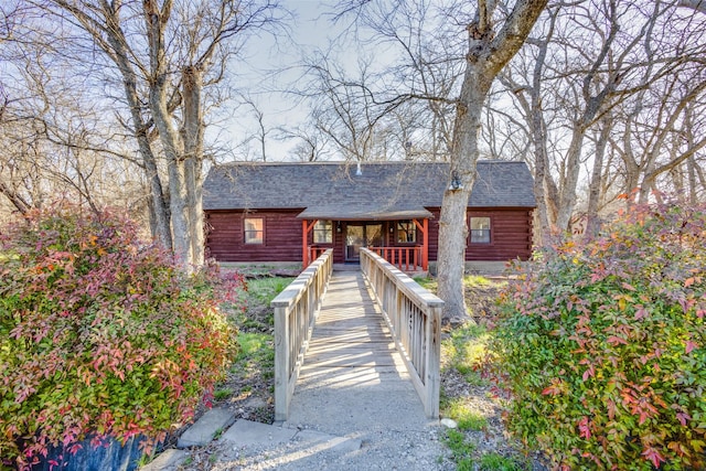 log-style house with log siding and a shingled roof