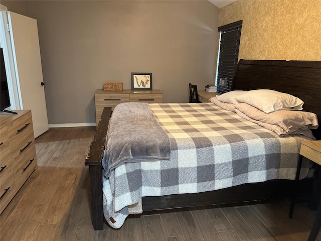 bedroom featuring dark wood finished floors and baseboards